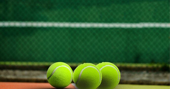 Composition of three tennis balls on tennis court with copy space