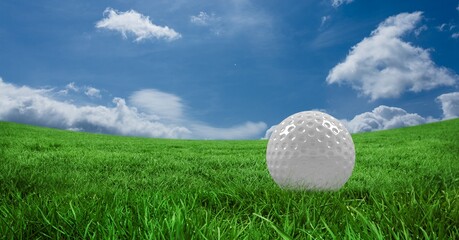 Composition of golf ball in grass, blue sky and copy space