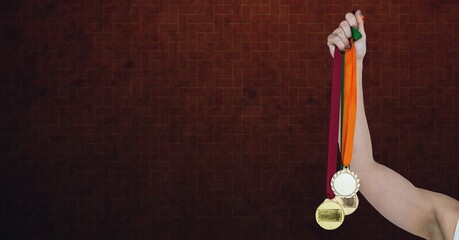 Fototapeta na wymiar Composition of caucasian female athlete holding medals with copy space on brick wall background