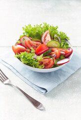 Healthy Salad with Tomatoes, Radish and Lettuce. Easy summer snack. Bright wooden background. Copy space. 
