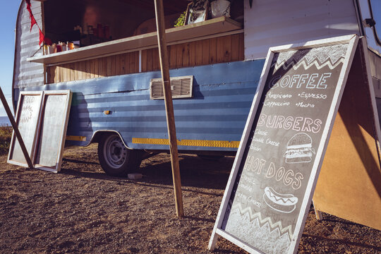 General view of food truck and menu board by seaside on sunny day