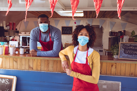 Portrait of diverse couple wearing face masks in food truck