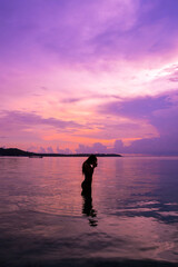 Fototapeta premium Woman silhouette at sunset on vacation