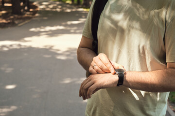 Close-up smart watch on a man's hand. Active lifestyle watch. Time management, mobility, social and technological concept. A man checks the time on his stylish watch
