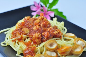 spaghetti on black dish on a white background