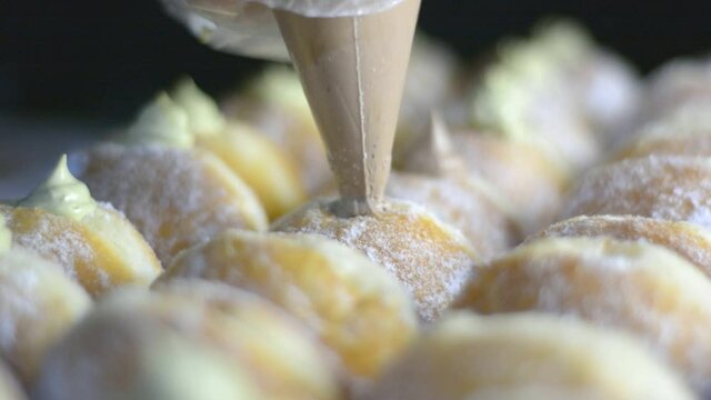 filling the bomboloni doughnut with vanila cream