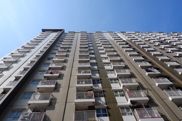 Residential multi storey building, bottom view with clear blue sky