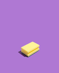 Yellow sponge on a purple background. Minimal layout. Creative idea.