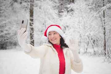Fototapeta na wymiar Beautiful girl in winter snowy forest in christmas clothes