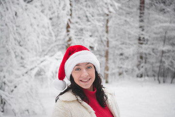 Fototapeta na wymiar Beautiful girl in winter snowy forest in christmas clothes
