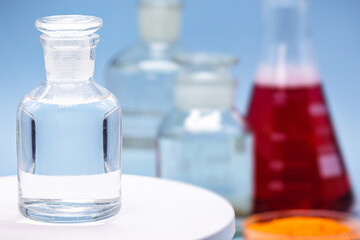 Reagent bottle with glass stopper, blue background, pharmacy or medicine concept, with copy space