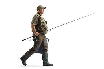 Full length profile shot of a mature fisherman in a uniform walking with a fishing rod