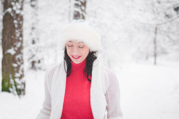 Beautiful girl in winter snowy forest in christmas clothes