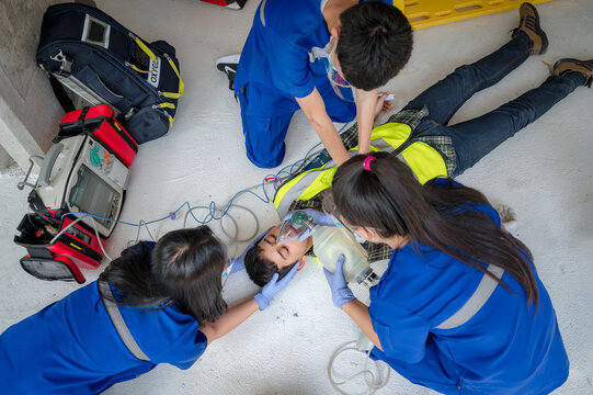 Emergency medical teams are helping unconscious patients by using automated external defibrillators (AED) and providing oxygen. During the rescue of unconscious workers at the construction site