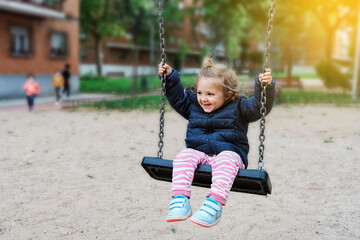 Toddler girl having fun on chain swing
