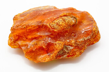 A beautiful transparent piece of natural amber on a white background. Sun stone. Red-yellow background. Fossilized ancient resin. Copal. Semi-precious mineral for jewelry. Amber texture 