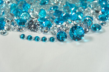 A group of aquamarine blue diamonds arranged in the middle of white diamonds on a white background..