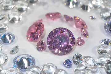 A group of pink diamonds arranged in the middle of white diamonds in a white background..Top view of pink diamonds. white diamonds background