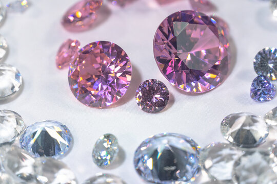 A group of pink diamonds arranged in the middle of white diamonds in a white background..Top view of pink diamonds. white diamonds background