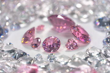 A group of pink diamonds arranged in the middle of white diamonds in a white background..Top view of pink diamonds. white diamonds background