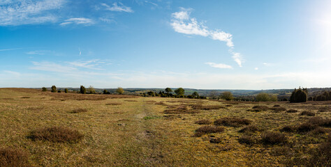 Fototapeta premium Panoramic view of countryside landscape and footpath through the empty field in the nature reserve. Photo taken at the hills of Brosarp, a popular outdoor tourist attraction in south of Sweden.