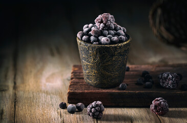 Frozen blueberries and blackberries on a rustic table