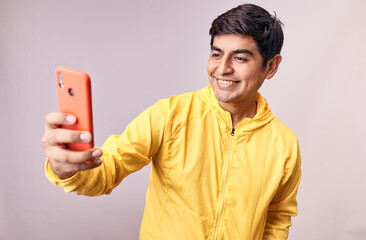 Hombre joven y feliz tomando una foto selfie mientras sonrie. Modelo aislado en fondo blanco 