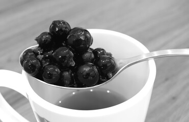 Black currant berries on a spoon.