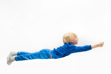 Little boy flying like superman. Dreaming. White background.