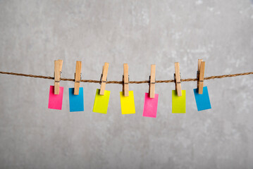 Small multicolored notes hang with clothespins on rope. Copy space. Place for your text. Reminder