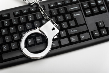 Handcuff is on the keyboard. Online fraud and criminal liability. Internet scam concept