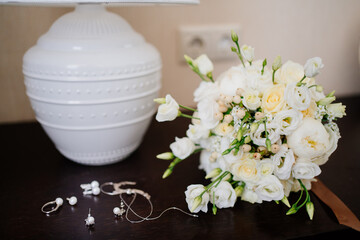 wedding bouquet and jewelry for the bride on the nightstand.