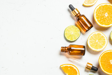 Vitamin C. Fresh citrus fruits with serum bottles with vitamin cosmetic products. Flat lay with copy space.