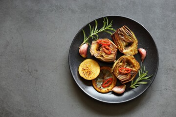 Roasted artichokes with lemon and herbs. Flat layot, copy space	