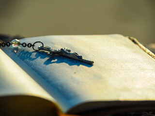 Close up crucifix pendant rosary on bible page with morning. Concept Love bible study. Book of...