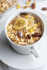 Bowl of milk with whole grains for breakfast. Muesli with dried fruits and dried fruits. On light background.