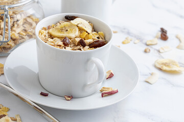 Bowl of milk with whole grains for breakfast. Muesli with dried fruits and dried fruits. With copy space. On light background.