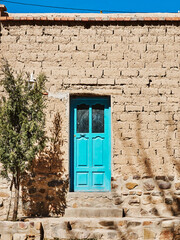 Turquoise door of a brick house.
