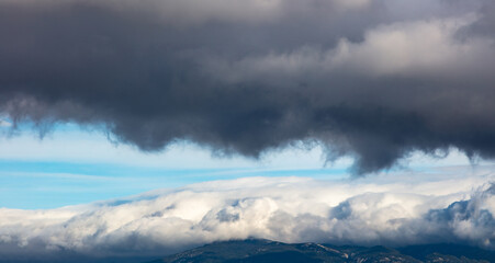 Fototapeta na wymiar Aerial, drone dark clouds on blue sky over mountains background.