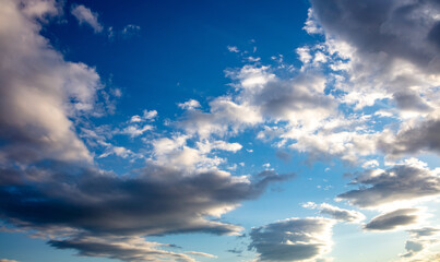 Fluffy white and gray clouds on blue sky background. Copy space.