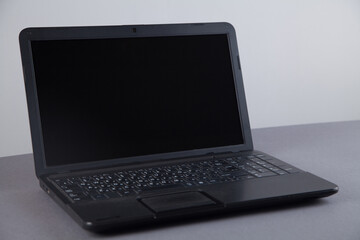 Fototapeta premium Black computer on gray table with empty screen.