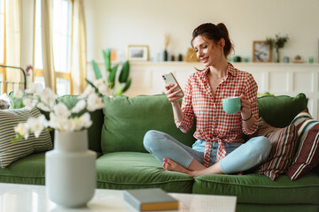 Cute happy woman holding cellphone, using mobile dating application to chat or sending romantic message. Woman with smartphone