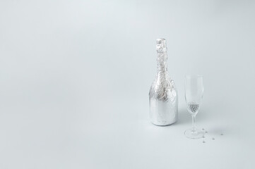 Silver champagne and glass on monochromatic background. Party card.