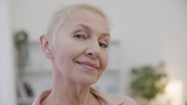 Wrinkled lady posing on cam, admiring natural beauty of ageing, self-acceptance