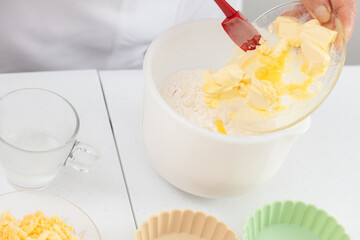 Senior woman preparing dough for a delicious cheese and ham tartlet