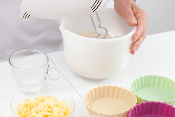Senior woman preparing dough for a delicious cheese and ham tartlet