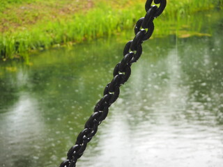 Wet chain with water drops near the pond