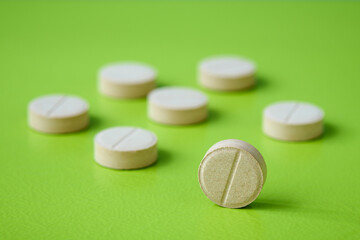 Medical pill closeup on green background. Medical drugs pills. Healthcare, pharmaceuticals and chemistry concept, shallow depth of sharpness