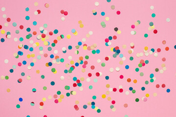multicolored paper confetti on pink isolated background