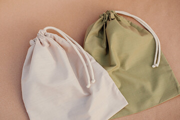 beige and green bag for fruits and vegetables on a paper background. concept of zero waste, the...